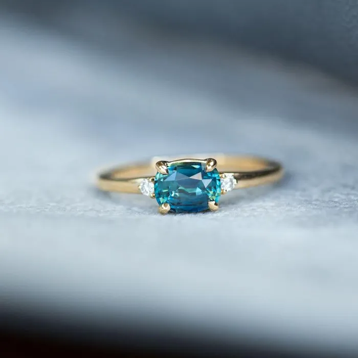 Rings Anueva Jewelry Teal Blue Three Stone Ring featuring 115ct cushion sapphire and diamonds in EastWest setting